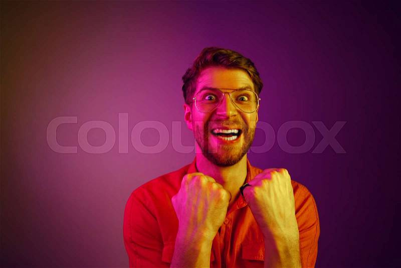 I won. Winning success happy man celebrating being a winner. Dynamic image of caucasian male model on blue studio background. Victory, delight concept. Human facial ..., stock photo