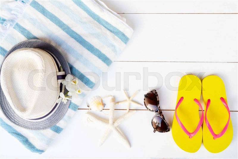 Summer flat lay top view scenery with hat, towel and flip flop sandals on white background with copy space, stock photo