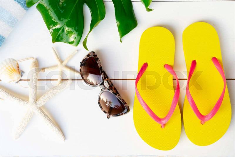 Summer flat lay scenery on white wooden background with flip flops, stock photo