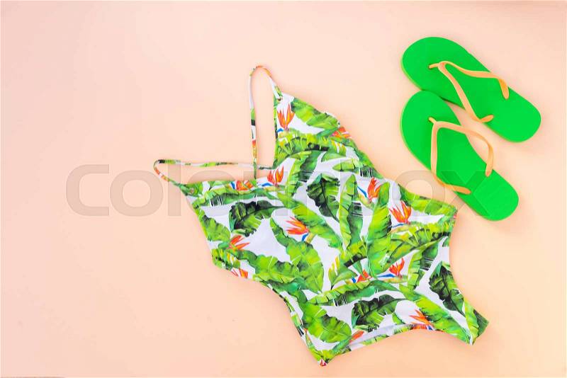 Summer flat lay scenery with swimmimg suit and sandals on pink background with copy space, stock photo