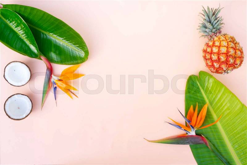 Summer flat lay scenery with tropical leaves, flowers anf fruits on pink background with copy space, stock photo