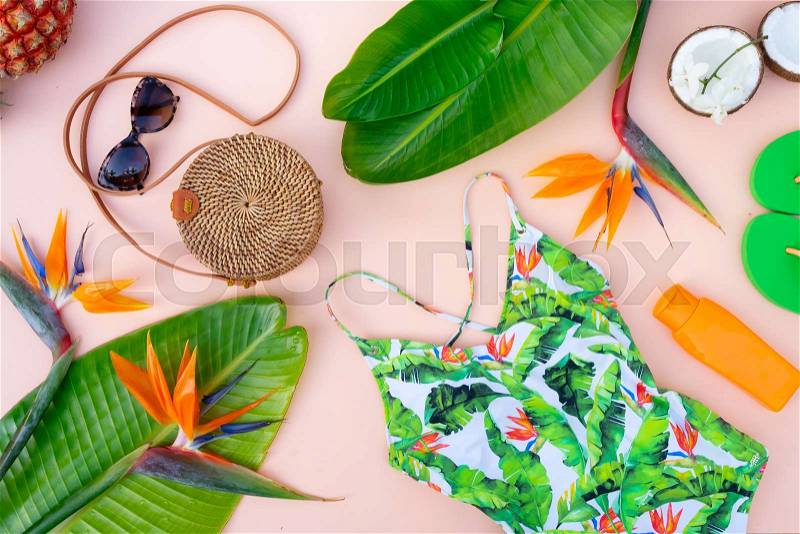 Summer flat lay scenery with beach accessories and tropical scenery on pink background, stock photo