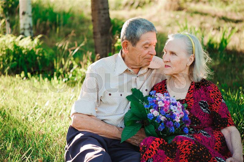 Beautiful happy old people sitting in the park, stock photo