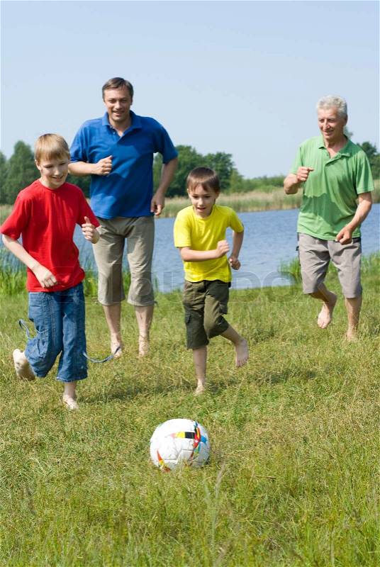 Happy family playing soccer, stock photo