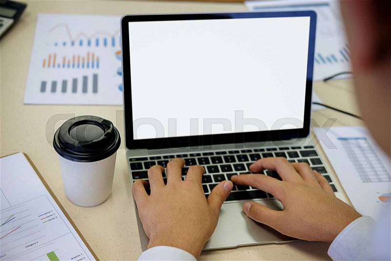 Businessman working at his coffee shop and using laptop, holding smartphone in hand discussing the charts and graphs showing the results of their successful ..., stock photo