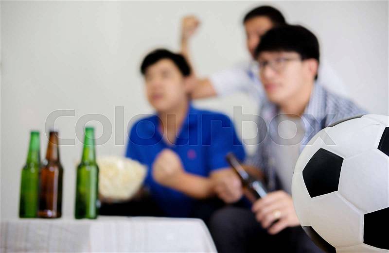 People watch soccer. Asian football supporters watching soccer on television at home with happy emotion, stock photo