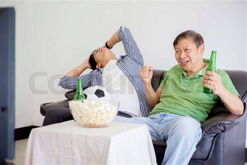 People watch soccer. Asian football supporters watching soccer on television at home with fun or disappoint emoticon, stock photo
