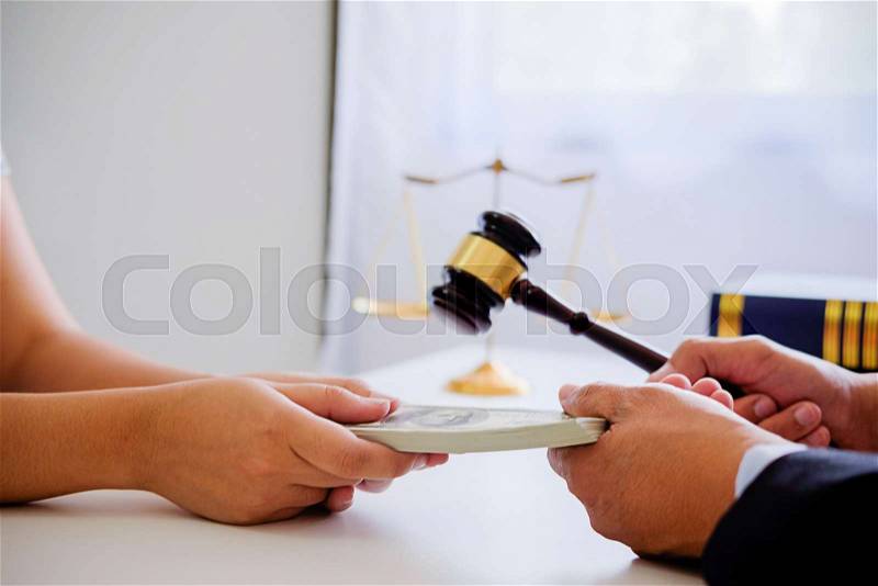 Lawyer businessman in suit hides money. A bribe in the form of dollar bills, stock photo