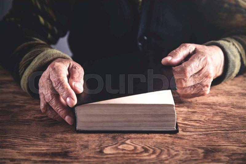 Hands of elderly woman with Bible. Religion concept, stock photo