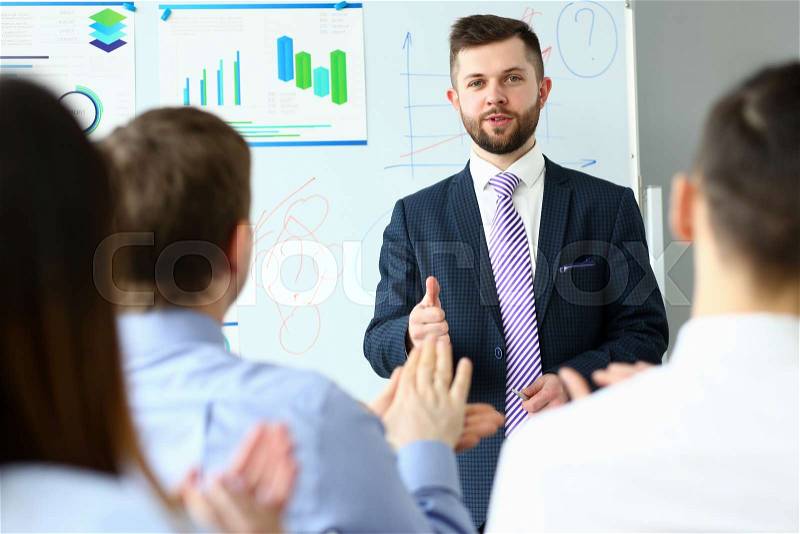 Young handsome teacher man in suit with workgroup seminar board with chart coaching background. Lecturer for applicants retraining financial statistics management ..., stock photo