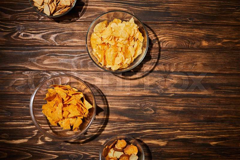 Top view of party snacks in bows on wooden table, stock photo