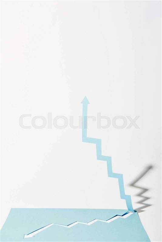 paper upward arrow from blue paper sheet on white background, stock photo