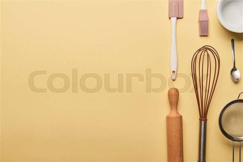 Flat lay with cooking utensils on yellow background with copy space, stock photo