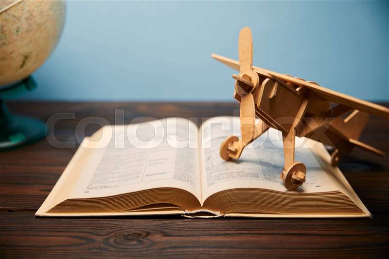Selective focus of book and toy plane on table, stock photo
