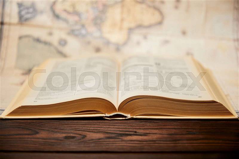 Selective focus of book and map on wooden table , stock photo