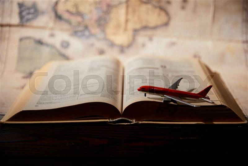 Selective focus of toy plane, book and map on table, stock photo