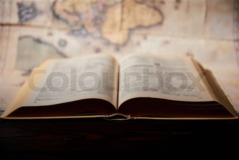 Selective focus of book and map on wooden table , stock photo