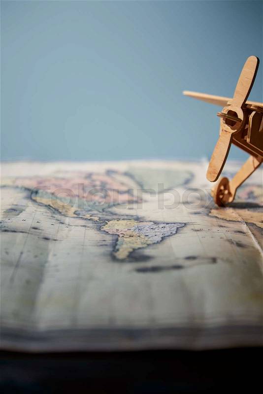 Selective focus of toy plane and map with copy space on table, stock photo