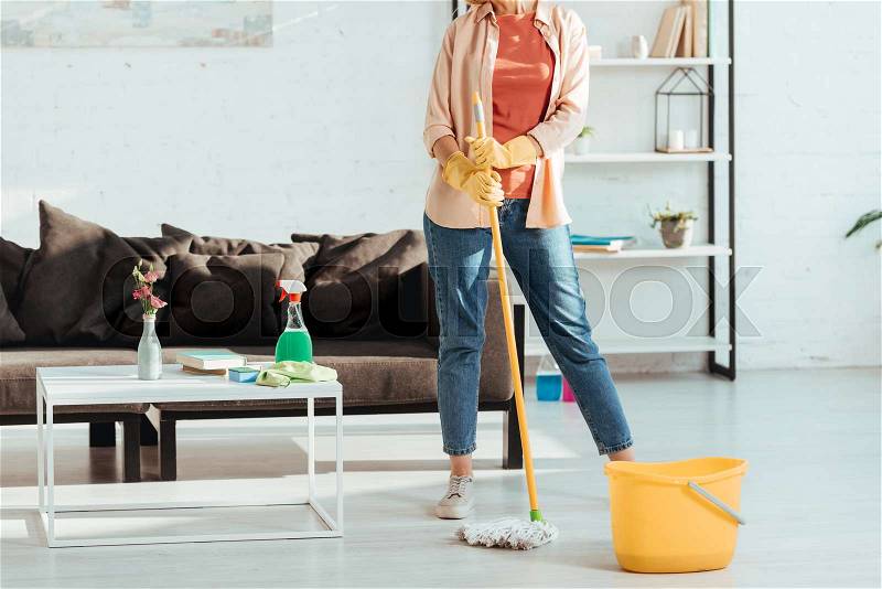 Cropped view of woman cleaning house with mop and bucket, stock photo