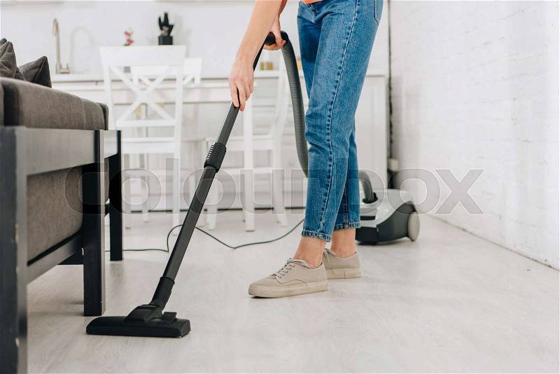 Cropped view of woman cleaning floor with vacuum cleaner, stock photo