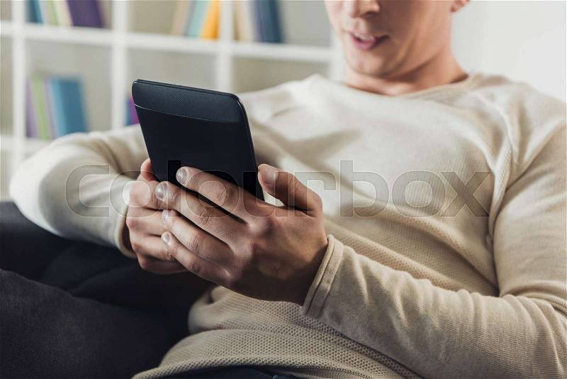 Cropped view of man holding e-reader in hands , stock photo