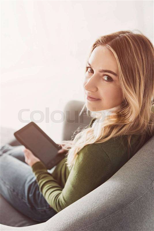 Happy woman studing with e-reader and smiling at home , stock photo