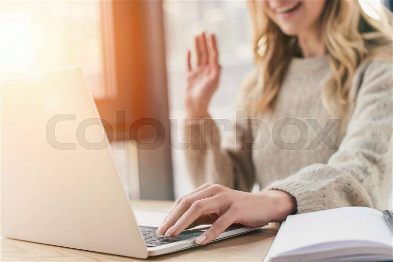Cropped view of woman waving hand while having video call , stock photo