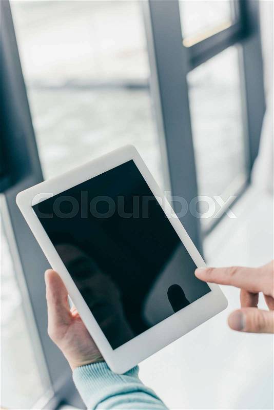 Cropped view of man pointing with finger at digital tablet with blank screen, stock photo