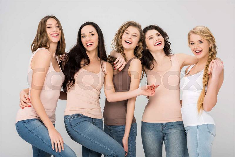 Cheerful young women laughing while standing together isolated on grey , stock photo