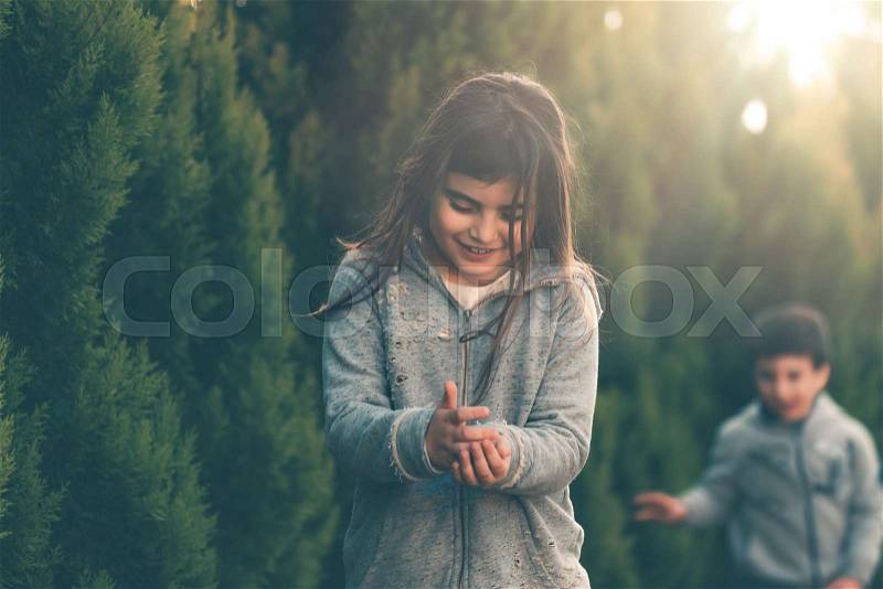 Happy friends hunting on eggs in the park in sunny day, brother and sister enjoying fun Easter tradition, religious holiday, stock photo