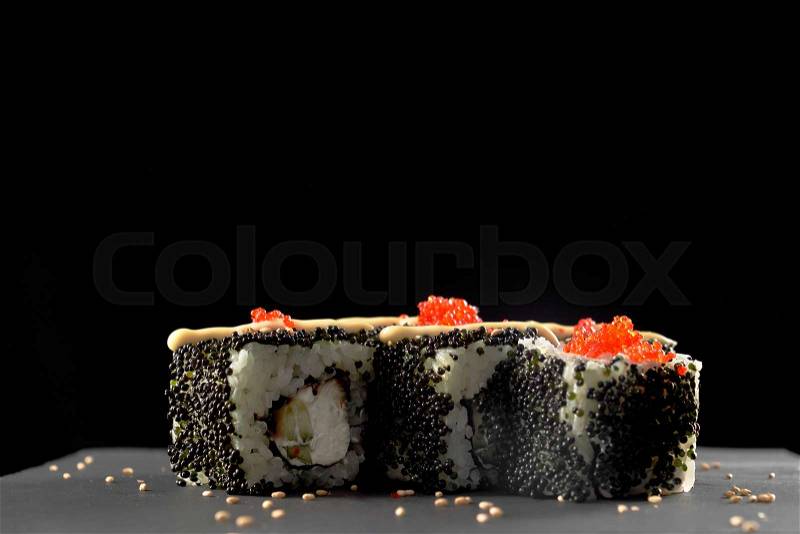 Philly sushi roll filled with cream cheese, fish and cucumber. Philadelphia maki topped with mayo and flying fish red roe, decorated with sesame, stock photo