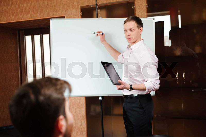 Businessman explaining business plan to coworkers in conference room, stock photo