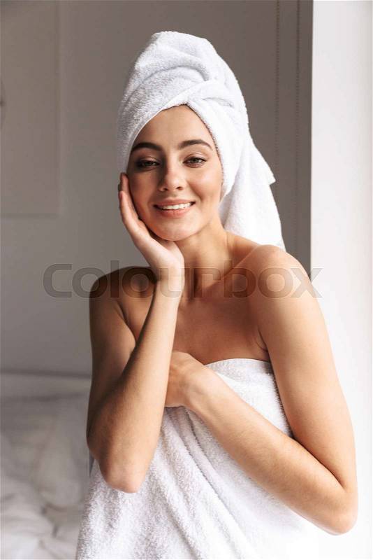 Photo of attractive woman wearing white towel, while standing in bathroom after shower in flat, stock photo