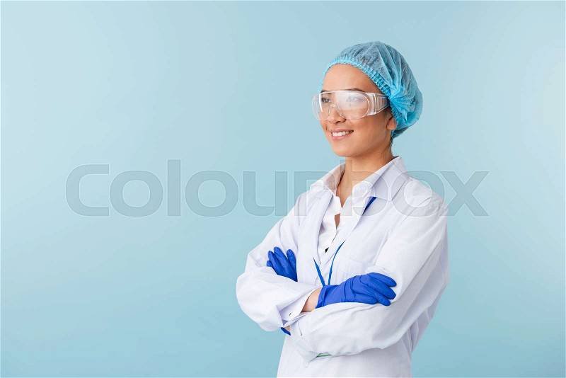 Photo of a young woman doctor posing isolated over blue wall background, stock photo