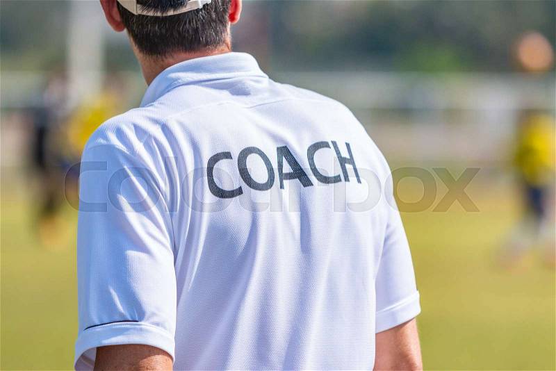 Back view of male sport coach in COACH shirt at an outdoor sport field, good for sport or coaching concept, stock photo