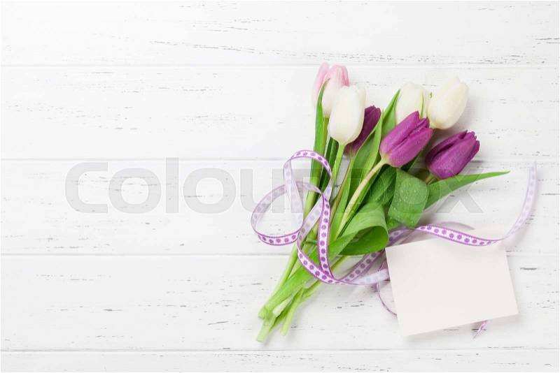 Easter greeting card with tulip flowers bouquet. Top view over white wooden table with space for your greetings, stock photo