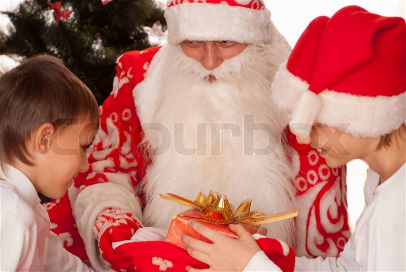 Santa gives presents to children, stock photo