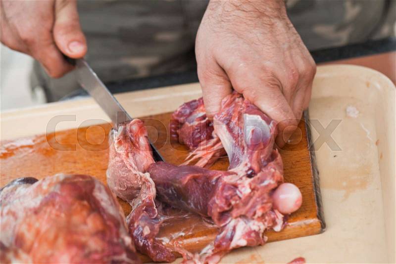 Raw lamb meat cutting, cook hands with knife, close-up photo, stock photo