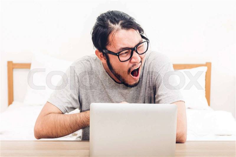 Man using digital laptop computer on the bed at home.man checking social apps and working.wireless technology concept, stock photo