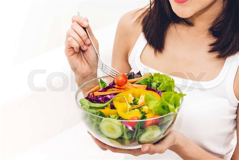 Happy woman eating and showing healthy fresh salad in a bowl.dieting concept.healthy lifestyle with green food, stock photo