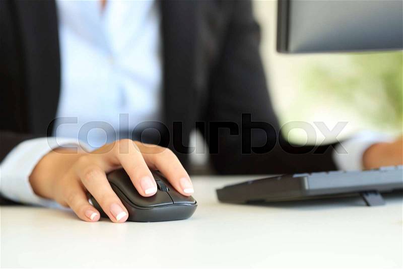 Close up of an office worker hand using computer mouse on a desk, stock photo