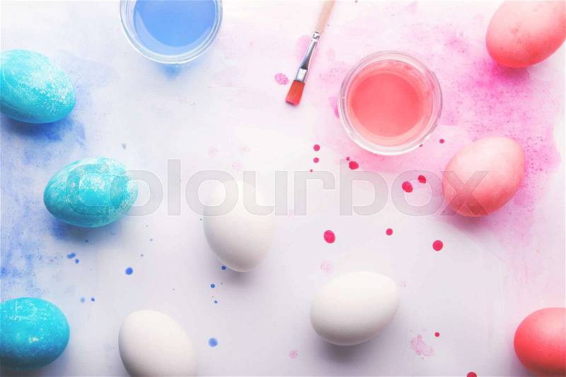 Painted eggs, paint and brush flat lay on a white background. Easter and spring composition. Studio shot. Copy space, stock photo