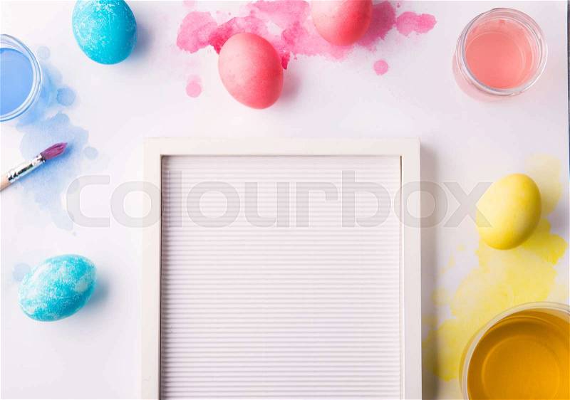 Painted eggs, paint and brush flat lay on a white background. Easter and spring composition. Studio shot. Copy space, stock photo