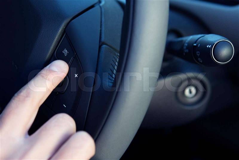 Driver Making Hands Free Call In Car With Button On Steering Wheel, stock photo