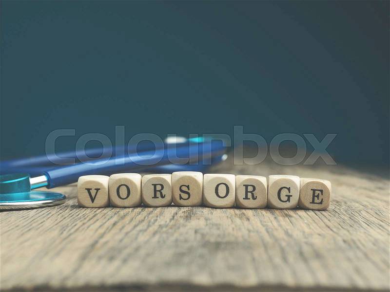 The German word prevention on small wooden dices with a stethoscope on a wooden table, stock photo
