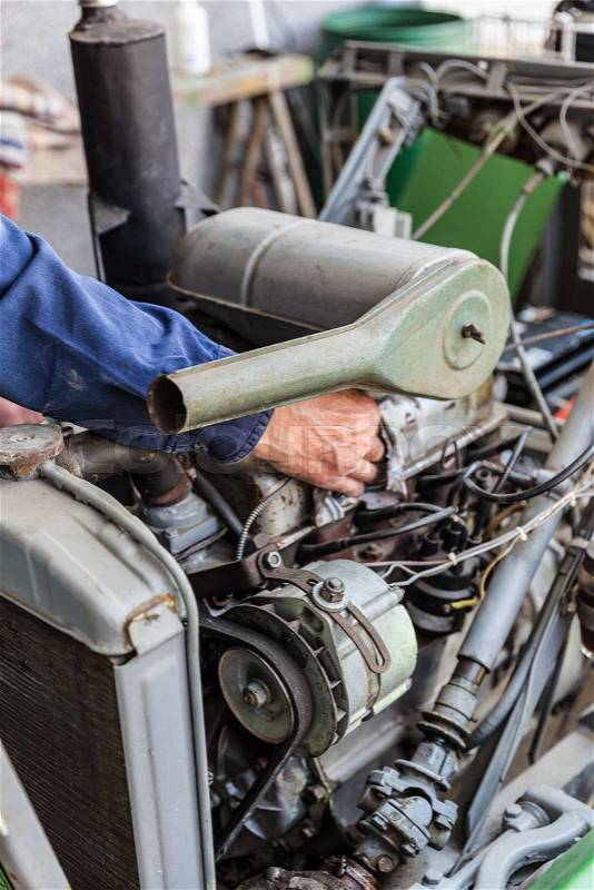 Man repairing old dirty car engine, stock photo