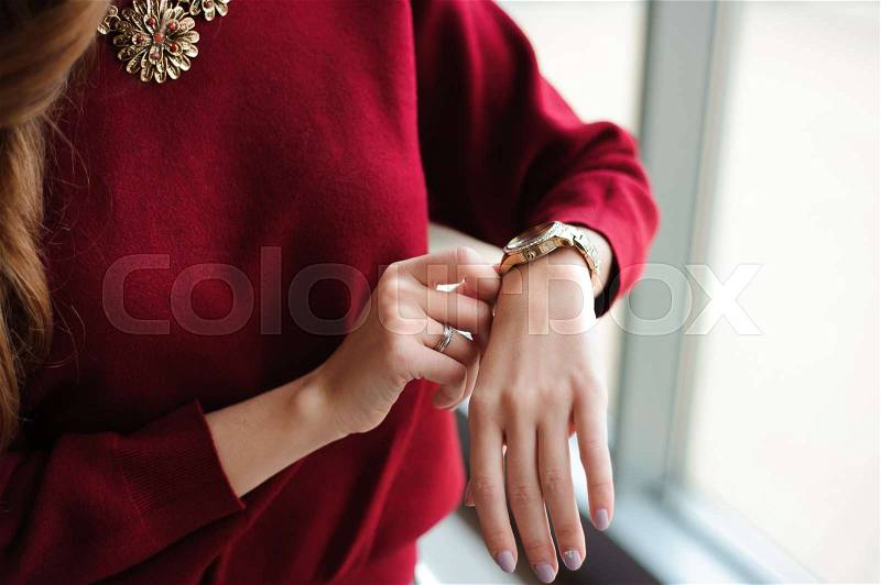 Beautiful woman looks at the clock waiting for the plane at the airport, stock photo