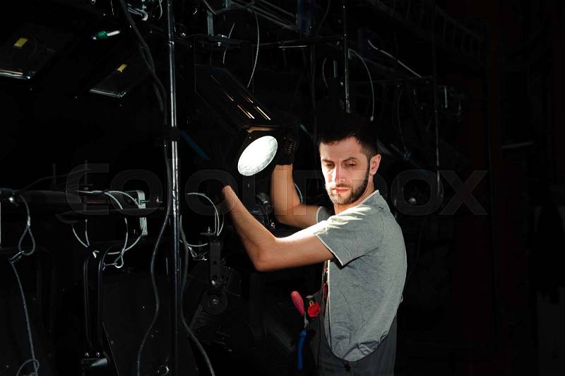 The stage worker sets up the lights, stock photo