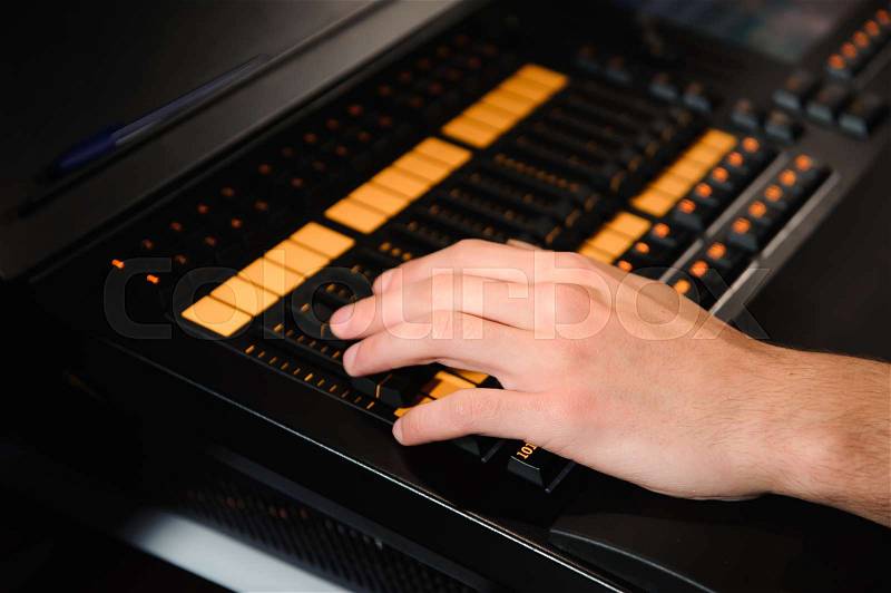 A lighting engineer works with lights technicians control on the concert show. Professional light mixer, mixing console. Equipment for concerts, stock photo