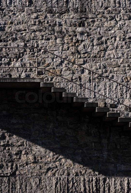 Outside stairs side view in the morning light against a stone wall. Minimalist architecture background with building exterior, stock photo